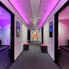 an empty room with purple lighting and pictures on the walls