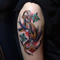 an anchor with rope and flowers on the arm