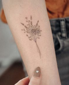 a woman's arm with a flower tattoo on the left side of her arm