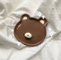 a chocolate teddy bear on top of a white sheet