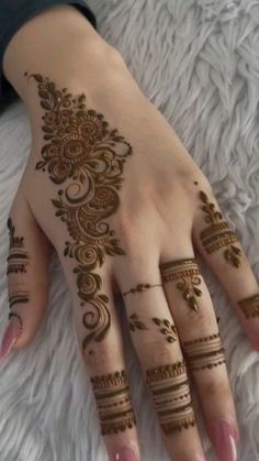 a woman's hand with henna tattoos on it