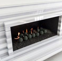 a white fireplace with rocks in it