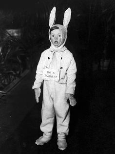 an old black and white photo of a child in bunny suit