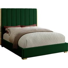 a bed with green upholstered headboard and pillows