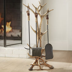 a fireplace with an antler's head and brooms in front of it