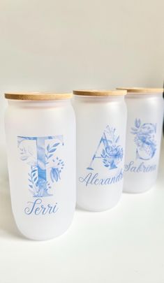 three white jars with blue designs on them