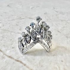 A stunning vintage diamond cocktail ring handcrafted in 16 karat white gold. It features 31 single cut diamonds weighing approximately 0.65 carat. The stones are approximately G-H color and VS2-SI1 clarity. Tested for 16 karat gold purity. It weighs 8.5 grams and is a size 7.25 US / O 1/2 UK. L: 0.97 inch. W: 0.82 inch. Birthstone: April. Condition: Very Good. Light scratches throughout metal. - 14 day return policy, no questions asked. - Free insured shipping in the US. - International shipping Diamond Crown Ring, Diamond Cocktail Ring, Diamond Crown, Crown Ring, Birthday Ring, Diamond Cocktail Rings, Gold Diamond Ring, White Gold Diamond Rings, Diamond Wedding Ring