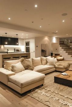 a living room filled with lots of furniture and a stair case in the back ground