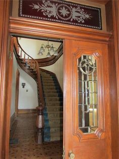 an entry way with a staircase and stained glass door leading to the second floor bedroom