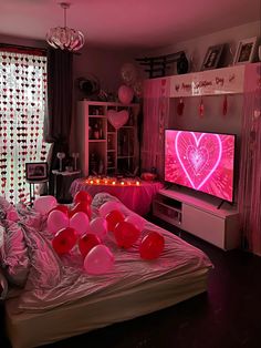 a bedroom with pink lights and balloons on the bed