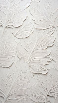 a white wall with leaves on it and the background is painted in shades of white