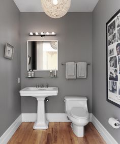 a white toilet sitting next to a sink in a bathroom under a round light fixture