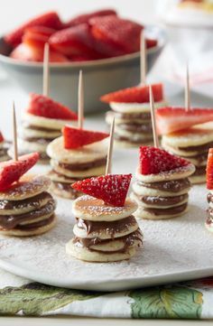 some pancakes with strawberries on them and toothpicks in the middle