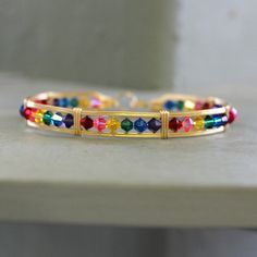 Indulge in the whimsical beauty of our handcrafted wire-wrapped bracelet in 14kt gold filled wire, adorned with rainbow crystal beads that sparkle all the way around your wrist. Each bead showcases a burst of vivid color, creating a joyous and celebratory accessory that instantly uplifts your spirits.  The fashionable design of this bracelet embraces the empowering message of love, pride, and diversity. Crafted as always with meticulous attention to detail, it exudes a stylish charm that brillia Adjustable Wire Wrapped Bangle As Gift, Adjustable Wire Wrapped Bangle For Gift, Bohemian Gold Crystal Bracelet Hand Wrapped, Handmade Bohemian 14k Gold-filled Bracelet, Handmade 14k Gold-filled Bohemian Bracelet, Handmade 14k Gold Filled Bohemian Bracelet, Bohemian Gold Hand Wrapped Crystal Bracelet, Wire Wrapped Bangle Wrap Bracelet As Gift, Gold Hand Wrapped Spiritual Crystal Bracelet