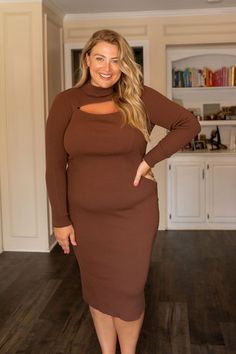 a woman in a brown dress posing for the camera with her hands on her hips