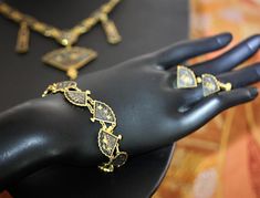 "This is truly a remarkable set in excellent vintage condition. Very nice weight and articulation. The bracelet is 7 1/2\". Earrings are screw back (typical to the age), and are 1/2\". And, the elaborately detailed necklace is 19\" with a 3\" pendant drop. Necklace is marked K24. Of similar vintage sets we have encountered, this is by far the nicest we have seen. Perfect for wear; nice enough for gifting. NOTE: We are happy to ship to our friends around the globe. Please contact us with any ques Victorian Hand Set Gold Jewelry, Victorian Hand-set Gold Jewelry, Formal Brass Jewelry With Intricate Design, Elegant Heavy Antique Gold Jewelry, Formal Intricate Brass Jewelry, Vintage Black Ceremonial Jewelry, Victorian Hand Set Jewelry For Formal Occasions, Heavy Ornate Jewelry For Ceremonial Occasions, Ornate Heavy Jewelry For Ceremonial Occasions