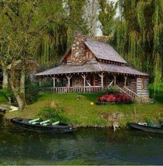 a small log cabin sits on an island in the middle of a lake surrounded by trees