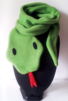 a black vase with a green scarf on it's head and a red tie around the neck