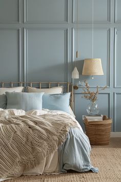 a bedroom with blue walls and white bedding