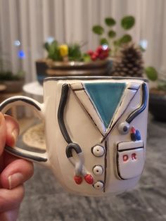 a hand holding up a coffee cup decorated with medical equipment