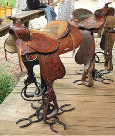 several different types of saddles are lined up on a wooden platform