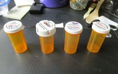 three bottles with orange liquid sitting on a table