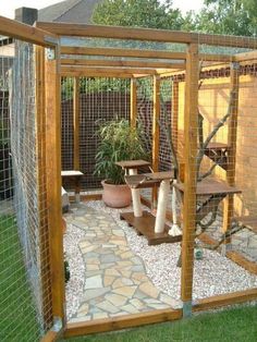 an outdoor area with plants and rocks in the grass, including a fenced in area