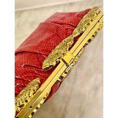 Well constructed water snake clutch in the spirit of Judith Leiber. Pleated snakeskin on a quality gold metal frame. Three crystal encrusted rosettes adorn the top. Immaculate interior. Circa 1980s. Elegant Red Clutch With Gold-tone Hardware, Red Clutch With Gold-tone Hardware For Evening, Designer Gold Clutch For Gala, Luxury Gold Clutch For Gala, Luxury Red Clutch For Evening, Luxury Red Clutch With Gold-tone Hardware, Luxury Red Evening Bag For Formal Occasions, Water Snake, Red Clutch