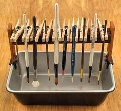 a rack with many different types of pens and brushes in it on a wooden floor