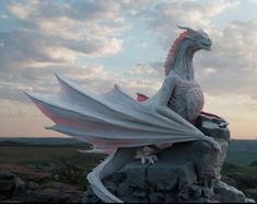 a white dragon statue sitting on top of a rock