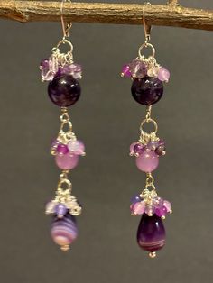 Artisan designed and handmade, dangling Pink and Purple Amethyst, Red Purple Jade, Pink and Lavender Jade Gemstones Chandelier Cluster Earrings. Exceptional colors purple, lavender and pink. From the top deep rich purple, 12 mm amethyst round bead underneath a cluster of pink, purple, and lavender.  These earrings are splendid dazzling beads, lavender jade 8 mm round, dangling beneath the second cluster. The final bead is chalcedony banded agate and underneath the third cluster gemstones.  These Cluster Chandelier, Purple Jade, Beaded Earrings Diy, Plum Purple, Pink Jewelry, Cluster Earrings, Red Purple, Handmade Sterling Silver, Purple Amethyst