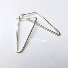 Minimal silver hoop earrings in a geometric triangle. A classic hoop with modern style in a brushed finish. Formed from solid sterling silver wire these triangle earrings have been hammered to emphasize the shape. Then given a brushed finish for a matte look. Two sizes available: Small = 2 cm in length. Large = 3 cm in length. Made from 20 gauge (.81mm thick) solid sterling silver wire. 20 gauge is the standard size for most lightweight hoops. You can enter my shop here: http://www.etsy.com/shop Geometric Hoop Earrings, Sleeper Earrings, Geometric Triangle, Triangle Earrings, Custom Earrings, Modern Earrings, Sterling Silver Hoops, Silver Hoops, Minimalist Earrings