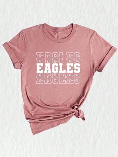 a pink t - shirt with the words eagles printed on it and tied at the front