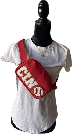 Cincinnati Reds Baseball Inspired Cross Body Bag/Belt Bag/Shoulder Bag. Stadium Approved Size Our Spirit Bag has a multi use strap with buckle closure allowing the bag to be used as a crossbody, fanny pack or shoulder bag. It is roomy for its compact size with a zipped pocket on the back and mesh pockets on both sides inside; one full pocket on one side and two smaller pockets on the other side. Each bag is crafted from lightweight nylon that makes it both waterproof and easy to clean. All added Red Crossbody Belt Bag With Adjustable Strap, Red Adjustable Strap Crossbody Belt Bag, Spirit Bags, Crossbody Fanny Pack, Cincinnati Reds Baseball, Reds Baseball, Bag Belt, Cincinnati Reds, Bag Shoulder