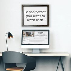 a desktop computer sitting on top of a wooden desk next to a lamp and chair