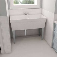 a white sink sitting under a window in a bathroom