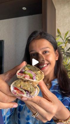 a woman holding a sandwich in her hands