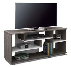 a flat screen tv sitting on top of a wooden entertainment center next to a bookshelf