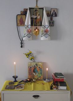 a white dresser topped with pictures and candles