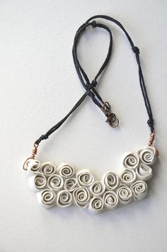 a white necklace with spirals on it