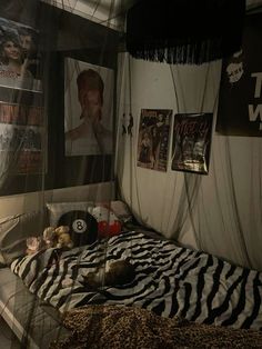 a bedroom with zebra print bedding and posters on the wall