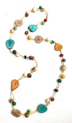 Multi-Color Tagua Long Necklace Ecuadorean Tagua Jewelry - Eco Friendly Color: Multi-Color Part Number: TAG541 Item Weight: .65oz Product Length: 35 inches long About Tagua This Product is handcrafted from a palm tree nut native to the lush tropical rainforests of Ecuador. Also referred to as the Ecuadorean Ivory Palm, the Tagua tree produces several bushels of seed pods a year with up to 100 Tagua nuts per pod. These nuts are then harvested, dried, and crafted into a wide range of products from Adjustable Yellow Lariat Necklace, Yellow Single Strand Bohemian Necklace, Yellow Bohemian Single Strand Necklace, Beige Jewelry With Colorful Beads For Jewelry Making, Elegant Multicolor Wooden Beads Necklaces, Unique Multicolor Lariat Necklace, Adjustable Cream Necklace With Colorful Beads, Beige Multi-strand Necklace For Gift, Cream Jewelry With Colorful Beads