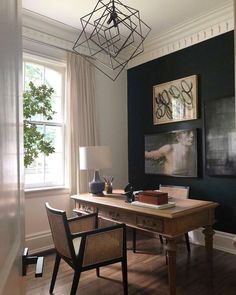 a home office with two chairs and a desk in front of a large painting on the wall