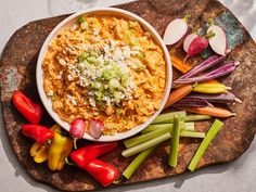 a bowl filled with food sitting on top of a cutting board next to sliced vegetables