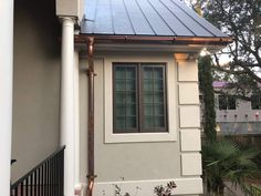 a house with a metal roof and white pillars