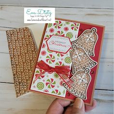 a hand holding up a christmas card with gingerbreads on it and a red ribbon