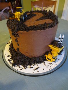 there is a chocolate cake with construction trucks on it