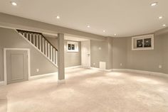 an empty living room with stairs leading up to the second floor