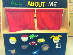 an all about me display with red curtains and cartoon characters on it's sides