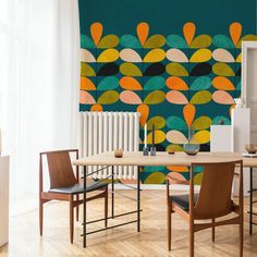 a dining room table with two chairs and a wall mural in the background that has circles on it